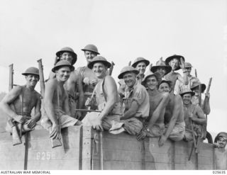 PORT MORESBY, PAPUA. 1942-07. SMILING CONFIDENTLY, THESE MEMBERS OF AN AUSTRALIAN ENGINEERING UNIT IN NEW GUINEA LOOK CAMERAWARDS FOR THE PHOTOGRAPHER BEFORE STARTING OUT ON A ROUTINE JOB