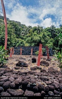 French Polynesia - Open site constructed of black rocks, red wooden figures