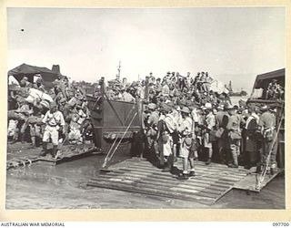 TOROKINA, BOUGAINVILLE. 1945-09-21. JAPANESE TROOPS FROM NAURU ISLAND, HAVING ARRIVED AT TOROKINA PER SS RIVER BURDEKIN, LEAVE THE BARGES TO GO ASHORE. THEY WILL THEN MARCH THE TEN MILES ALONG PIVA ..
