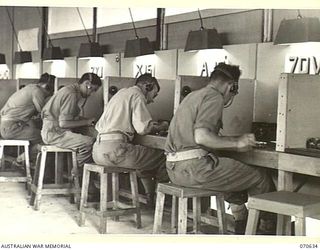 PORT MORESBY, PAPUA, 1944-02-26. OPERATORS OF THE 18TH LINES OF COMMUNICATION SIGNALS MANNING TELEGRAPH CHANNELS IN THE TELEGRAPH ROOM AT THE NEW GUINEA FORCE SIGNAL OFFICE