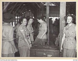 LAE, NEW GUINEA. 1945-05-07. AUSTRALIAN WOMEN'S ARMY SERVICE PERSONNEL CARRYING TRUNKS TO THEIR SLEEPING QUARTERS SHORTLY AFTER ARRIVAL AT THE NEWLY CONSTRUCTED AWAS BARRACKS IN BUTIBUM ROAD. THEY ..