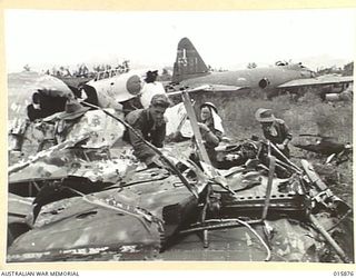 1943-10-01. NEW GUINEA. FALL OF LAE. AUSTRALIAN TROOPS INSPECT A SMASHED JAPANESE PLANE ON THE AIRSTRIP AT LAE