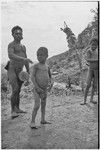 Man wearing luluai badge plays kundu drum