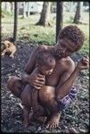 Woman smoking a cigarette, baby leaning against her