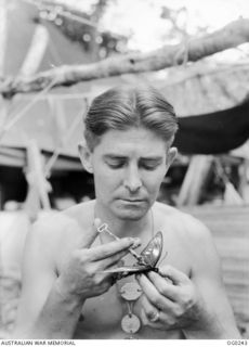 NEW GUINEA. C. 1943. LEADING AIRCRAFTMAN K. W. GILL OF SYDNEY, NSW, WHO IS SERVING WITH A RAAF UNIT AND COLLECTS BUTTERFLIES IN THE JUNGLE. HE MADE A HYPODERMIC SYRINGE OUT OF A PIECE OF GLASS ..
