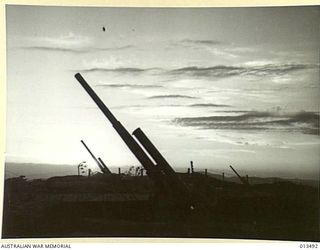 1942-11-06. SHOT OF AN AUSTRALIAN ANTI-AIRCRAFT BATTERY SOMEWHERE IN NEW GUINEA. THIS BATTERY IS MANNED ENTIRELY BY VICTORIANS USING GUNS MANUFACTURED IN A VICTORIAN FACTORY AND THEIR BAG OF ENEMY ..