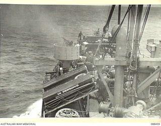 AT SEA, BETWEEN FINSCHHAFEN, NEW GUINEA AND BIAK. 1945-04-04. A VIEW FROM THE BRIDGE OF THE VAN HEUTSZ, KPM LINE, AS A US ARMY GUNNER FIRES HIS .50 INCH HEAVY ANTI-AIRCRAFT MACHINE GUN AT A ..