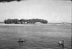 Fale/Fakaofo village islet with outrigger canoes in foreground.