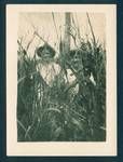 Two unidentified men with dog, standing amongst tall grass, New Guinea, c1929 to 1932