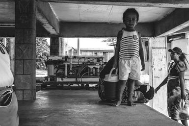 Child infront of broken water filter, Fakaofo, Tokelau