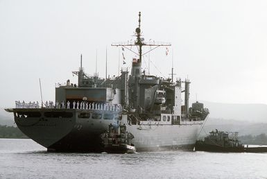 The large harbor tugs NOGALES (YTB 777) (foreground) and KETCHIKAN (YTB 795) assist the combat stores ship USS NIAGARA FALLS (AFS 3) upon her arrival at Naval Station Guam