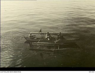 Los Negros Island, Admiralty Group. c. 1943. A group of natives paddling a small outrigger canoe