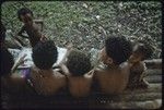 Children look at magazines while they sit on house veranda