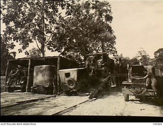 Lae, New Guinea. 1944-06-30. Transport personnel checking trucks at HQ, New Guinea Force