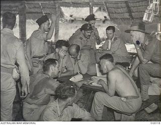 VIVIGANI, GOODENOUGH ISLAND, PAPUA. 1943-10-12. BEAUFIGHTER AIRCREW OF NO. 30 SQUADRON RAAF BEING "DEBRIEFED" BY THE INTELLIGENCE OFFICER AFTER A BIG AIR ATTACK ON RABAUL. THE INTELLIGENCE OFFICER, ..