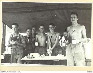 MOTUPINA POINT AREA, BOUGAINVILLE ISLAND. 1945-01-20. THE STAFF OF THE COOKHOUSE OF NO.5 BATTERY, 2ND FIELD REGIMENT ENJOY A MORNING CUP OF TEA AFTER CLEARING UP THE BREAKFAST THINGS. IDENTIFIED ..