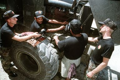 MASTER SGT. Edward Sanders (left) a mechanic from Dyess Air Force Base, Texas works on a forklift alternator with Chuuk mechanic, Naphan Aliven (center) and trainee, Joseph Aiten. SGT. Sanders is a member of a thirteen man civic-action team, on 8-months temporary duty, and chartered to enhance the socio-economic development of Chuuk, while providing a U.S. military presence at this island 632 miles southeast of Guam. Exact Date Shot Unknown . Published in AIRMAN Magazine August 1997