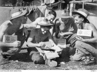 MALMAL VILLAGE, NEW BRITAIN. 1944-12-24. TROOPS OF HEADQUARTERS, 5TH DIVISION OPENING THEIR CHRISTMAS HAMPERS. IDENTIFIED PERSONNEL ARE: PRIVATE (PTE) J. BARRON (1); PTE R. FREW (2); CORPORAL R. H. ..