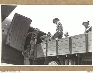 WARD'S DROME, NEW GUINEA. 1943-11-16. TROOPS OF THE 2/5TH AUSTRALIAN FIELD REGIMENT, 7TH AUSTRALIAN DIVISION PREPARING TO LOAD A LONG 25-POUNDER GUN INTO A DOUGLAS TRANSPORT AIRCRAFT, DURING AN ..