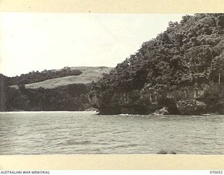 GNEISENAU POINT, NEW GUINEA. 1944-01-24. A VIEW OF GNEISENAU POINT TAKEN FROM THE SEA, SHOWING IN THE BACKGROUND TWO BEACHED LANDING CRAFT MECHANIZED AND A SUBMERSIBLE JAPANESE OIL TANKER. THE ..