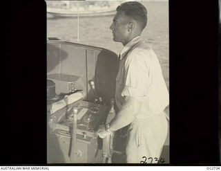 PORT MORESBY, PAPUA. C. 1944. THE HELMSMAN OF A MOTOR LAUNCH OF THE RAAF RESCUE SERVICE
