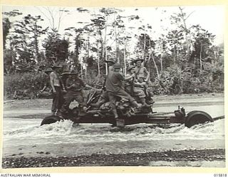 1943-09-25. NEW GUINEA. ADVANCE ON LAE. ARTILLERY BEING TOWED ACROSS THE BUREP RIVER ON THE WAY TO LAE