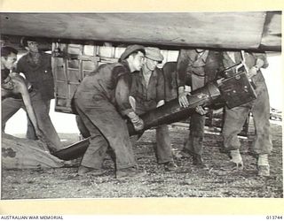 NEW GUINEA. A 105MM M-3A1 HOWITZER COMPLETE WITH SPARES, TRACTOR AND AMMUNITION IS UNLOADED SOMEWHERE IN THE BATTLE AREA. THE GUN CREW ALSO CAME WITH THE GUN. PICTURE SHOWS THE BARREL OF THE GUN ..