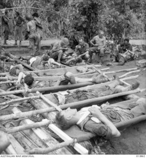 1942-12-16. PAPUA. GONA. WOUNDED AUSTRALIANS RECEIVE TREATMENT IN THE FRONT LINE. (NEGATIVE BY G. SILK)