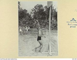 BOUGAINVILLE. 1945-04-25. SIGNALMAN M.G. FORD 58/59 INFANTRY BATTALION (1), MAKES A HIGH SHOT FOR GOAL DURING THE BASKET BALL COMPETITION AT 2/3 CONVALESCENT DEPOT TABLOID SPORTS. THIS IS PART OF ..