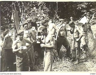 BOUGAINVILLE ISLAND. 1945-02-03. PERSONNEL OF THE 5TH FIELD COMPANY, ENGAGED IN REPAIRING THE MAWARAKA- MOSIGETTA ROAD, ENJOY A CUP OF TEA BROUGHT UP TO THEM BY THE YOUNG MEN'S CHRISTIAN ..