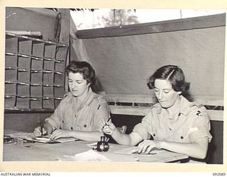 LAE, NEW GUINEA, 1945-05-21. CORPORAL I.C. ARCHIBALD, POSTAL CORPORAL (1), WITH CORPORAL B. HAHN (2), WORKING IN THE ORDERLY ROOM AT THE AUSTRALIAN WOMEN'S ARMY SERVICE BARRACKS IN BUTIBUM ROAD