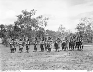 POM POM VALLEY, NEW GUINEA. 1943-11-27. GUARD OF THE 2/10TH. AUSTRALIAN INFANTRY BATTALION, THE CHAMPIONS OF THE 18TH. AUSTRALIAN INFANTRY BRIGADE, MARCHING ACROSS THE PARADE GROUND DURING THE ..