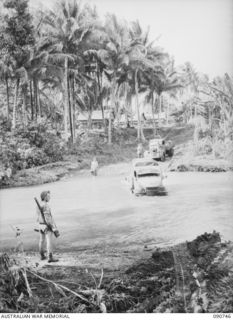 MILNE BAY, NEW GUINEA. 1942-09-14. AN ARMY VEHICLE TRAPPED BY FLOODWATERS NEAR HAGITA HOUSE FORD