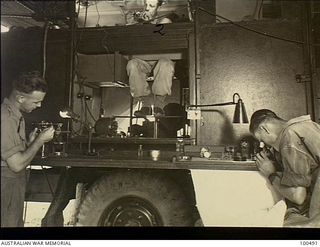 Port Moresby, New Guinea. 1944-05-30. Instrument makes of 126 Brigade Workshop, Australian Electrical and Mechanical Engineers (AEME), repairing watches and artillery predictor instruments. Left to ..
