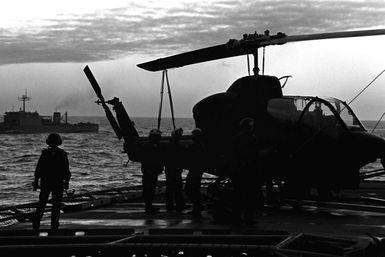 A Marine AH-1 Sea Cobra helicopter from Marine Light Helicopter Squadron 167 (HML-167) is loaded aboard the amphibious assault ship USS GUAM (LPH-9) for the trip to Norway. The Cobra will be used in support of the 1ST Battalion, 6th Marines, cold weather training