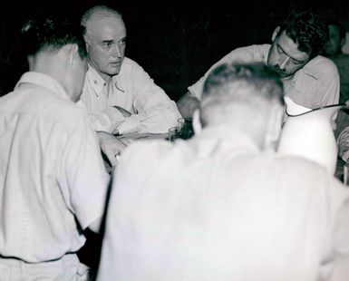 Photograph of Captain Charles B. McVay Talking to Correspondents After the Sinking of the USS Indianapolis (CA-35) at Guam