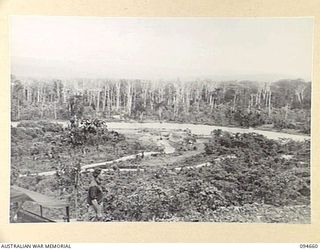 TOL AREA, NEW BRITAIN. 1945-08-02. THE VIEW FROM A HILL LOOKING DOWN ON THE WULWUT RIVER. THE BRIDGE HAS BEEN WASHED AWAY BY FLOODS AND ENGINEERS OF 4 FIELD COMPANY, ROYAL AUSTRALIAN ENGINEERS, ARE ..