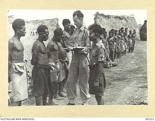 DUMPU, NEW GUINEA. 1944-01-04. NG2446 SERGEANT J. B. BRENNAN, MEDICAL ORDERLY, AUSTRALIAN AND NEW GUINEA ADMINISTRATION UNIT, (1) ATTACHED TO THE 7TH DIVISION, ASSISTED BY MAKU, A PAPUAN "DOCTOR ..
