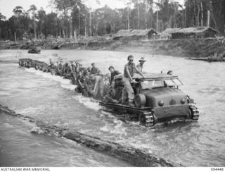 SOUTH BOUGAINVILLE. 1945-07-24. A TRACTOR TRAIN LOADED WITH 29 INFANTRY BRIGADE TROOPS AND SUPPLIES CROSSING THE MOBIAI RIVER. IT IS TOWED BY A JAPANESE PRIME MOVER RECENTLY CAPTURED FROM THE ENEMY ..