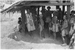 People hanging up money by side of house in what is probably a compensation payment