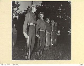 LAE, NEW GUINEA. 1944-07-27. PERSONNEL OF NO. 22 PLATOON, F COMPANY, 2/1ST GUARD REGIMENT FORM RIGHT DRESS DURING THE NIGHTLY STRIKING OF THE FLAG. THIS PLATOON MAINTAINS GUARD DUTIES FOR ..