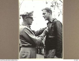 1942-11-28. NEW GUINEA. LIEUT GENERAL GEORGE KENNY DECORATES WITH A SILVER STAR STAFF SERGEANT FRED CHRISTMAS OF RUTLAND, VERMONT. CHRISTMAS WAS A MEMBER OF A FLYING FORTRESS CREW WHICH SANK A ..