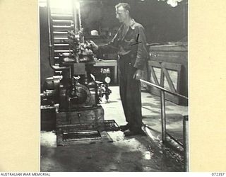 PORT MORESBY, NEW GUINEA. 1944-04-18. TX15066 SAPPER G.H. BRIEN, 8TH ARMY TROOPS COMPANY, CHECKS A COMPRESSOR IN THE FREEZING PLANT AT THE NO. 1 COLD STORE, AUSTRALIAN ARMY SERVICE COMPANY AT ELA ..