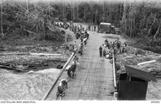 LAE, NEW GUINEA, 1945-11-20. TROOPS OF LAE BASE SUB AREA MAKING THEIR WAY ALONG THE WHARF TO BOARD THE TROOPSHIP MV DUNTROON FOR THEIR RETURN TO AUSTRALIA, WHILE THE LOUD-SPEAKER ON THE SALVATION ..