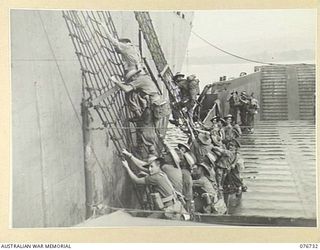 BOUGAINVILLE ISLAND, SOLOMONS. 1944-11-01. TROOPS OF THE 3RD AUSTRALIAN DIVISION AND ATTACHED TROOPS CLIMBING DOWN THE NETS OVER THE SIDE OF THE LIBERTY SHIP, LINDLEY M. GARRISON INTO AMERICAN ..