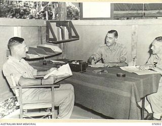 LAE, NEW GUINEA. 1944-11-16. SX16834 MAJOR H.S. DAULBY, COMMANDING OFFICER, DISTRICTS ACCOUNTS OFFICE, ARMY PAY CORPS (2) HOLDING A CONFERENCE IN HIS OFFICE WITH VX133296 LIEUTENANT W.N. TOLLEY (1) ..