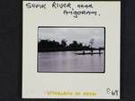 Three people on canoe moving along Sepik River, near Angoram, [Papua New Guinea, 1969?]