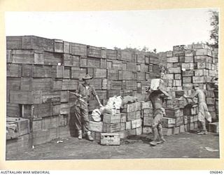 TOBOI WHARF, NEW BRITAIN. 1945-09-18. SERGEANT J. BLOOMFIELD, 1 ADVANCED SUPPLY DEPOT, SUPERVISING A JAPANESE WORKING PARTY WHO ARE MOVING STORES AT THE DETAIL ISSUING DEPOT. FOLLOWING THE ..