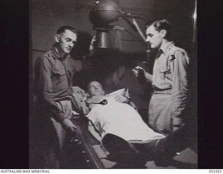 KOITAKI, NEW GUINEA. 1943-06-29. X-RAY ROOM OF THE 2/2ND AUSTRALIAN CASUALTY CLEARING STATION. LEFT TO RIGHT: SX18264 PRIVATE E. THROWER, SURGICAL ORDERLY; SX18195 LANCE CORPORAL L. E. SMITHSON, ..