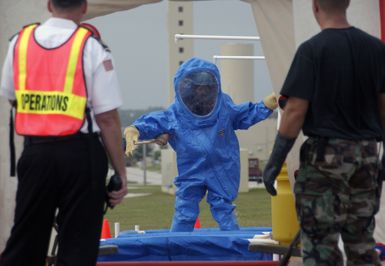 A U.S. Air Force hazardous materials response team AIRMAN, attired in protective suit, goes through a decontamination line after responding to a minor explosion in a warehouse at Andersen Air Force Base (AFB), Guam, on Jan. 12, 2005. The AIRMAN is a member of the 36th Civil Engineer Squadron here at Andersen AFB. (USAF PHOTO by TECH. SGT. Cecilio Ricardo) (Released)